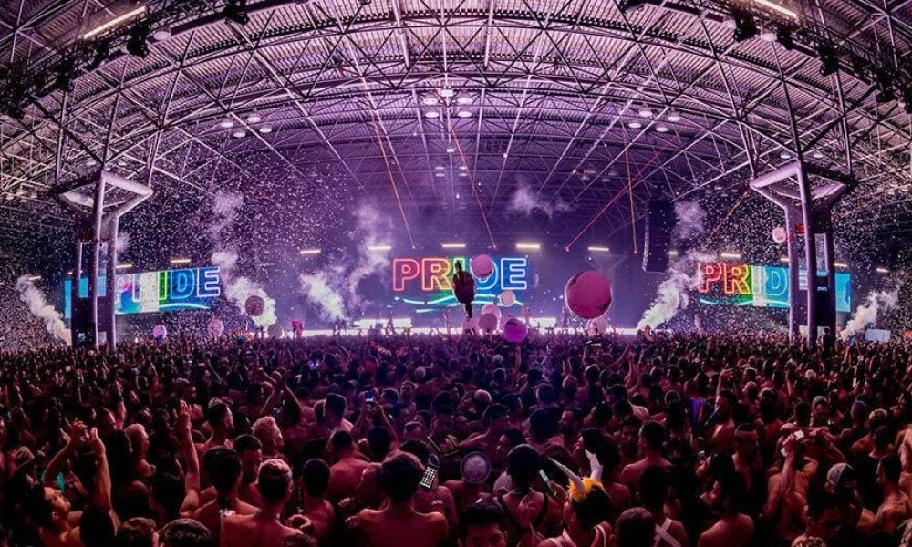 Crowd and illuminated stage at a Jake Resnicow LGBTQ+ festival.